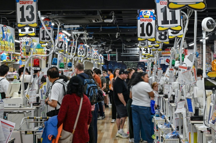 At a large Don Quijote store in Tokyo's bustling Shibuya district, hundreds of tourists rush to fill their baskets with snacks and souvenirs