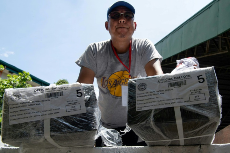 A worker prepares to unload ballots at a polling station Sunday in Manila on the eve of the Philippine election