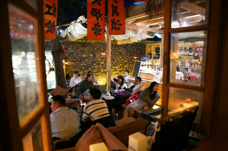 Young Chinese chat after watching a musician perform at a "youth retirement home"
