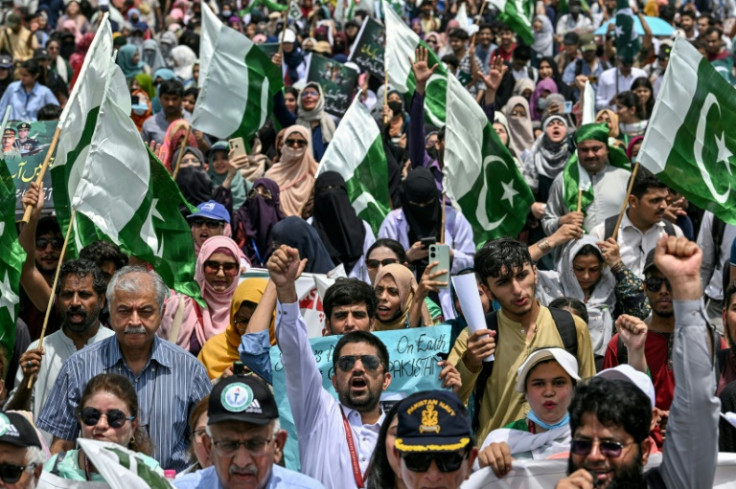 Students and teachers hold Pakistan flags as they shout anti-India slogans during a rally in Karachi
