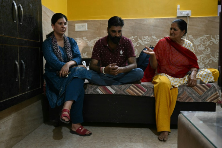 Shruti Sharma (R) sits with her husband Sandeep Sharma and mother in law Champa Devi in their living room