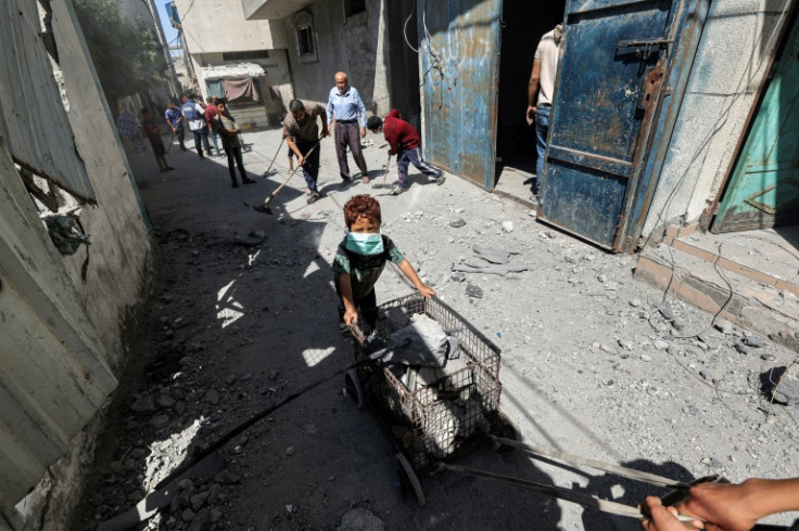 A man and boy transport a cart loaded with rubble following Israeli bombardment in the Bureij camp for Palestinian refugees in central Gaza