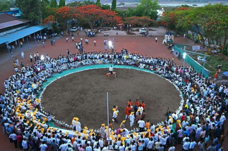 Spectators watch a bout of traditional mud wrestling during competition