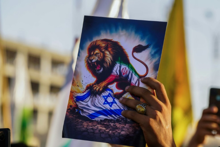 A man lifts a placard as Iraqi protesters, including clerics and tribal leaders, rally in support of Iran against the US and Israel in Iraq's Shiite holy city of Najaf