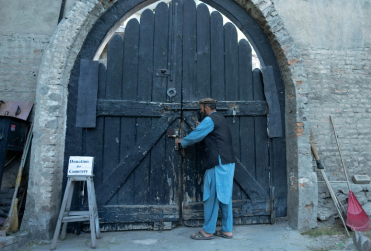 Gravekeeper Aynullah Rahimi unlocks a door at the British Cemetery in the Sherpur neighbourhood of Kabul, home to generations of foreign fighters, explorers and devotees of Afghanistan