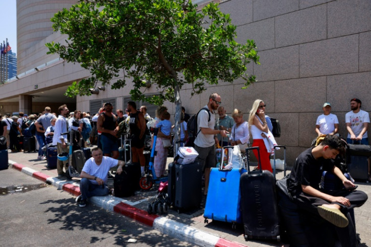 People arrive with their luggage before the departure of buses slated to evacuate foreign passport holders, mainly European and Polish, out of Israel, at a meeting point in Tel Aviv