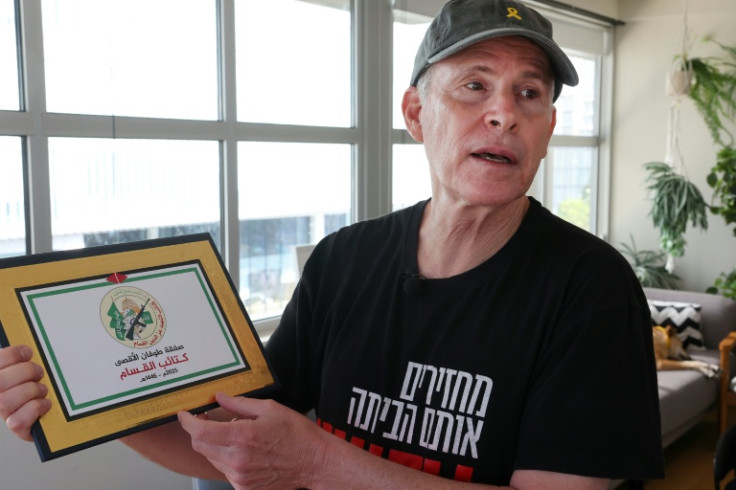 Siegel holds a certificate he received from the armed wing of Hamas on the day he was released from Gaza