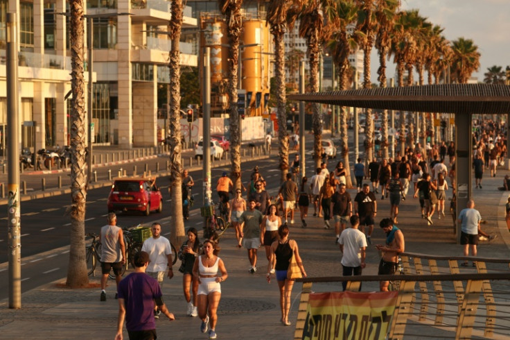 People walk on the promenade in Tel Aviv following the start of a ceasefire between Israel and Iran