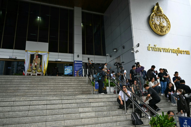 Journalists wait outside Bangkok's Criminal Court as former leader Thaksin Shinawatra is due to face charges of insulting the monarchy