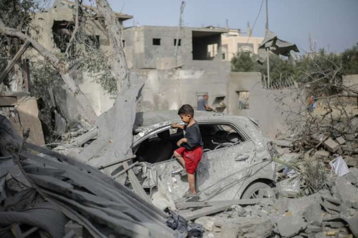 Palestinian children picked through the wreckage around a destroyed home in Deir el-Balah, central Gaza