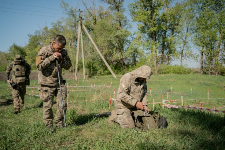 A Ukrainian police unit prepare to demine a field at Korobochkino near Kharkiv