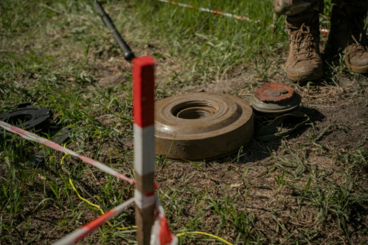 Pereverzev uses his tractor to clear mines in fields in Korobchyne village, Kharkiv region