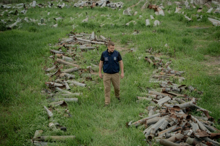 Ukrainian official Dmytro Chubenko with piles of Russian shells fired into the Kharkiv region