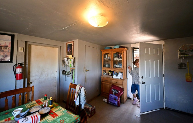 Christine Shorty, 70, turns on a light for the first time in her home after it was connected to the power grid