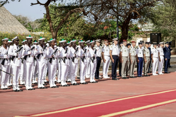 French army staff (R) and Senegalese army staff (L) arrive ahead of a ceremony where France will return Camp Geille, its largest base in the country, and its airfield at Dakar airport
