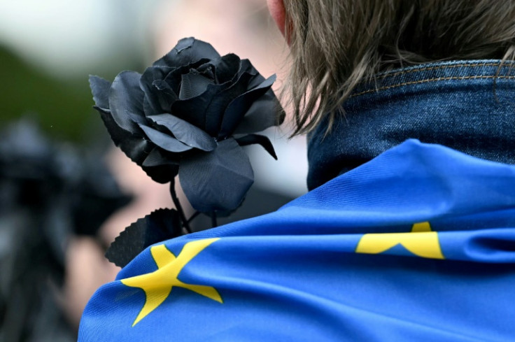 A small group of around 20 protesters held up black roses