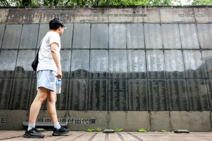 A man walks past the names of prisoners of war etched into granite at the Taiwan POW Memorial and Peace Park