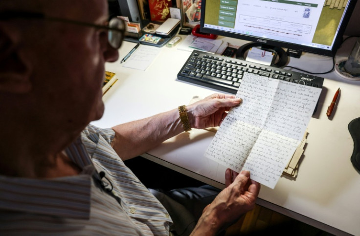 Michael Hurst shows one of the letters he has received from POW families