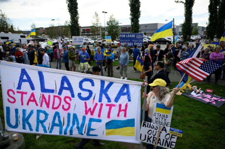 Demonstrators wave flags and hold a banner as they rally in support of Ukraine along Seward Highway in Anchorage, Alaska, on August 14, 2025, on the eve of the scheduled meeting between the US and Russian presidents