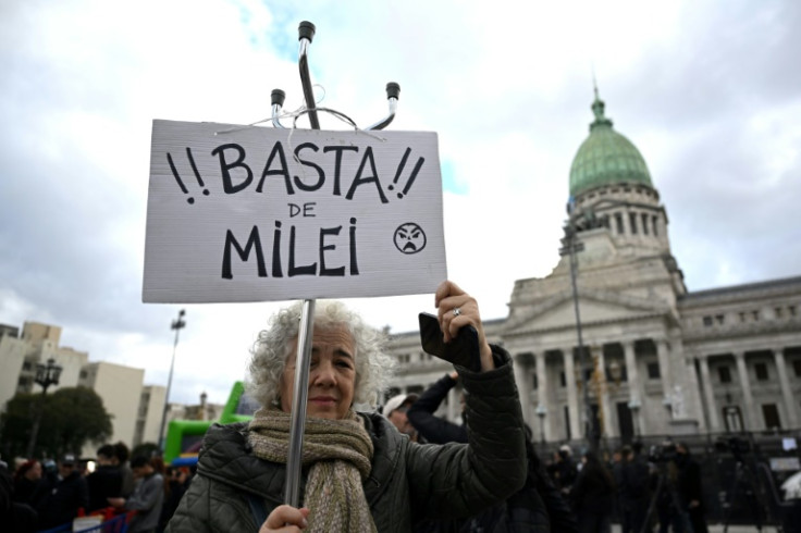 A woman holds a sign that reads in "Enough of Milei," outside of National Congress in Buenos Aires