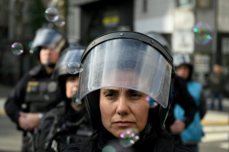 A police officer stands guard as protesters gather outside the National Congress