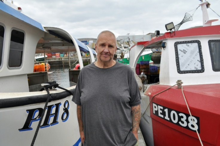 Fisherman Brian Tapper, 53, poses next to two of his purpose-built crab fishing vessels in Plymouth Harbour, but predicts crab numbers 'won't come back in his working lifetime'