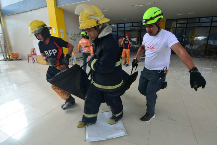 Rescuers carry a bag containing a dead body retrieved from an indoor arena in San Remigio town, Cebu province, central Philippine