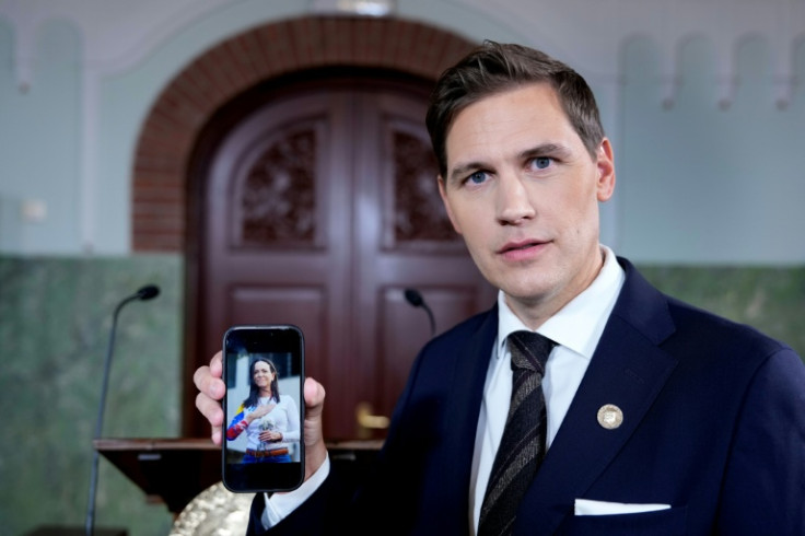 Chair of the Norwegian Nobel Committee Jorgen Watne Frydnes holds his smartphone with a photo of Peace Prize winner Machado