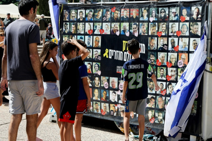 People look at portraits of the captives being held in Gaza at the so-called "Hostages Square" in Tel Aviv