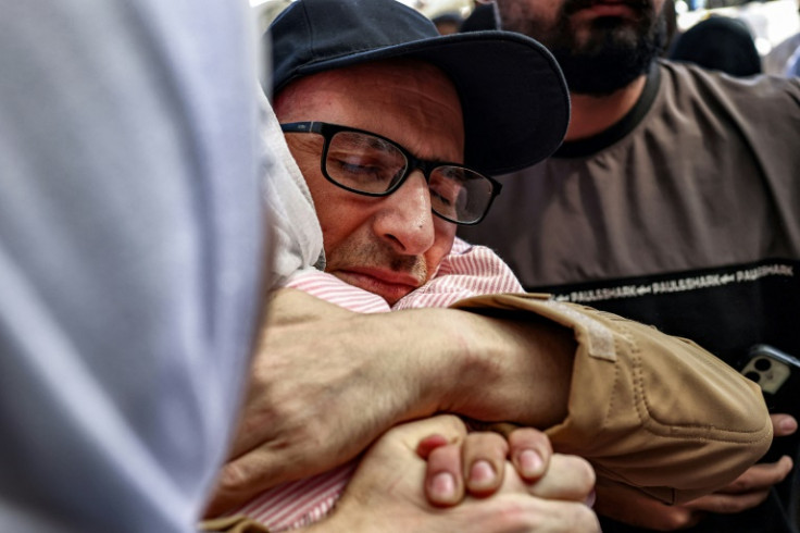 One of the Palestinian prisoners, who was released in a prisoner-hostage swap and ceasefire deal between Israel and Hamas, is embraced by a woman relative upon arrival by bus at Ramallah Cultural Centre in Ramallah in the occupied West Bank, on October 13