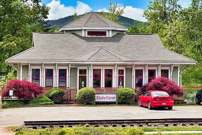 A State Farm Insurance office occupies a classic railroad depot