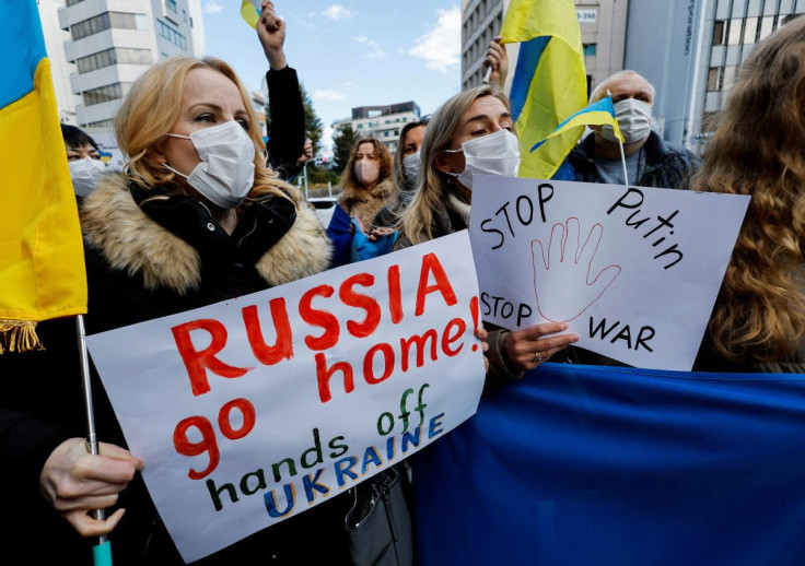 Ukrainians residing in Japan hold placards and flags during a protest rally denouncing on Russia over its actions in Ukraine, near Russian embassy in Tokyo