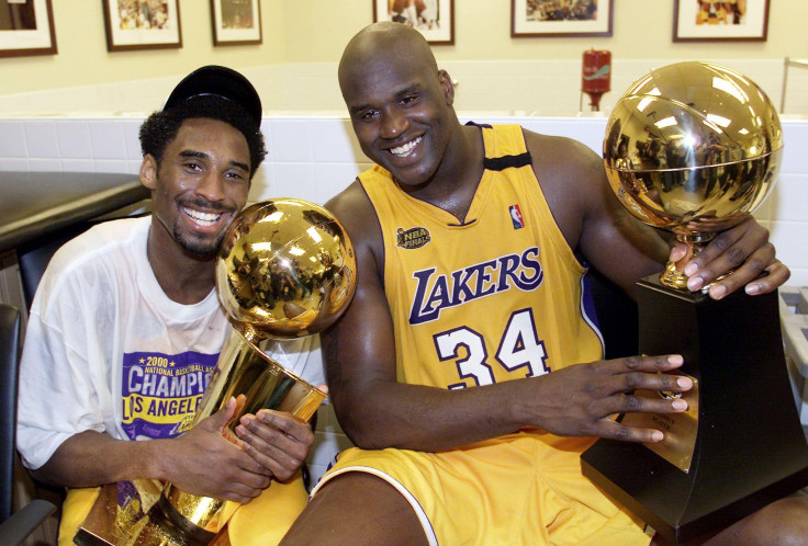 Kobe Bryant (L) of the Los Angeles Lakers holds the Larry O'Brian trophy as teammate Shaquille O'Neal (L) hold the MVP trophy after winning the NBA Championship against Indiana Pacers 19 June, 2000
