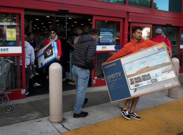 Shoppers carry televisions purchased from a store during Black Friday sales in Los Angeles