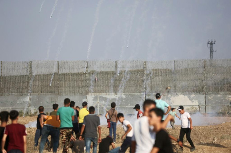 Palestinian protesters in Gaza watch incoming tear gas canisters shot by Israeli security forces amid clashes near the border fence on Saturday