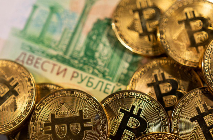 Illustration shows Russian rouble banknotes and representations of the cryptocurrency Bitcoin