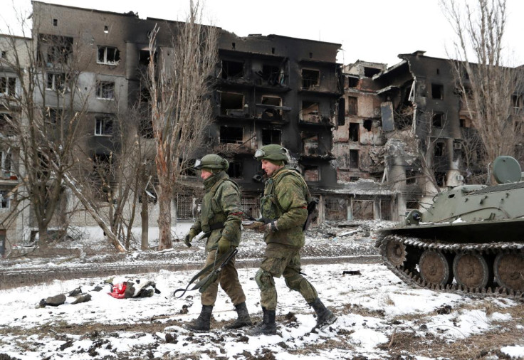 Service members of pro-Russian troops walk near a residential building which was heavily damaged during Ukraine-Russia conflict in Volnovakha