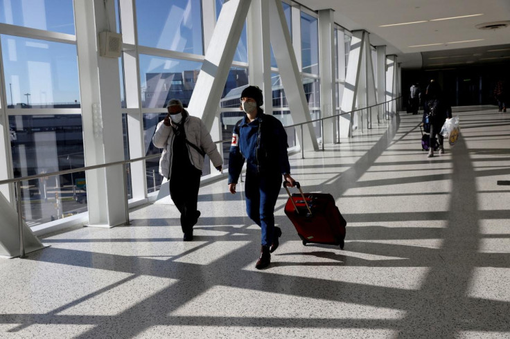 Air travellers wearing a protective face masks, amid the coronavirus disease (COVID-19) pandemic, at JFK International airport in New York