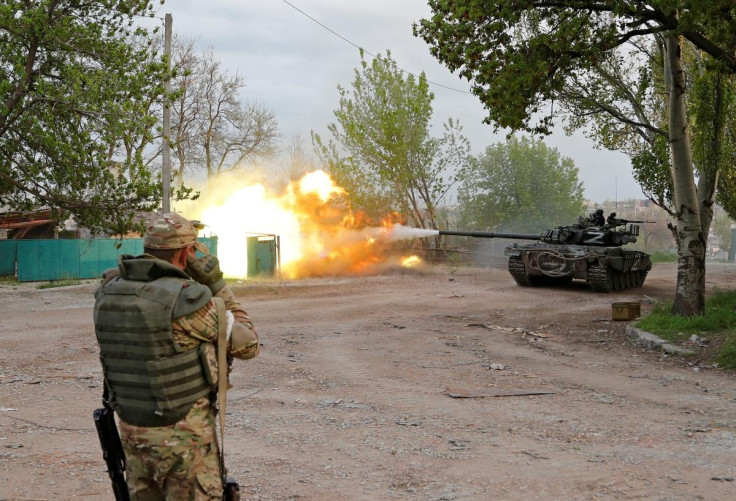 Service members of pro-Russian troops fire from a tank in Mariupol