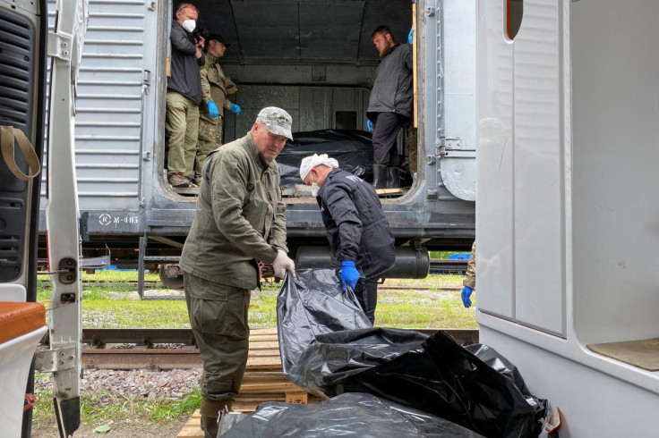 Ritual workers load bodies of killed Russian soldiers to refrigerated rail car, in Kharkiv