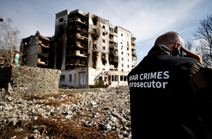 War crime prosecutor's team member speaks on the phone next to buildings that were destroyed by Russian shelling, amid Russia's Invasion of Ukraine, in Borodyanka